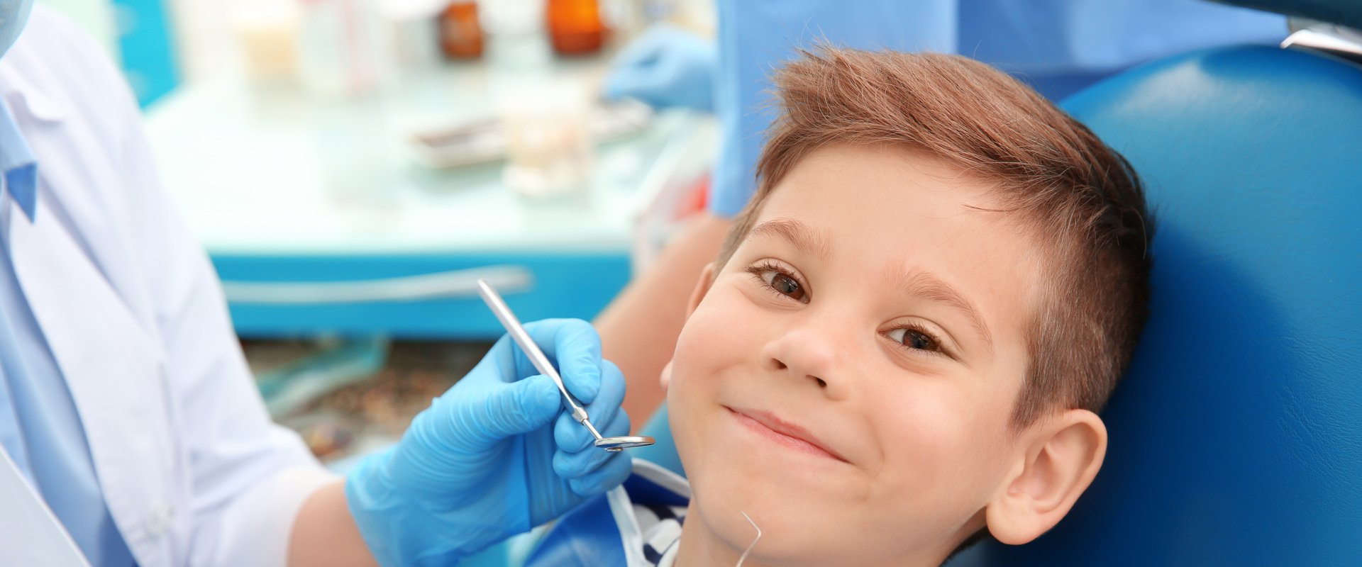 Pediatric dentist examining a young patient during a dental exam