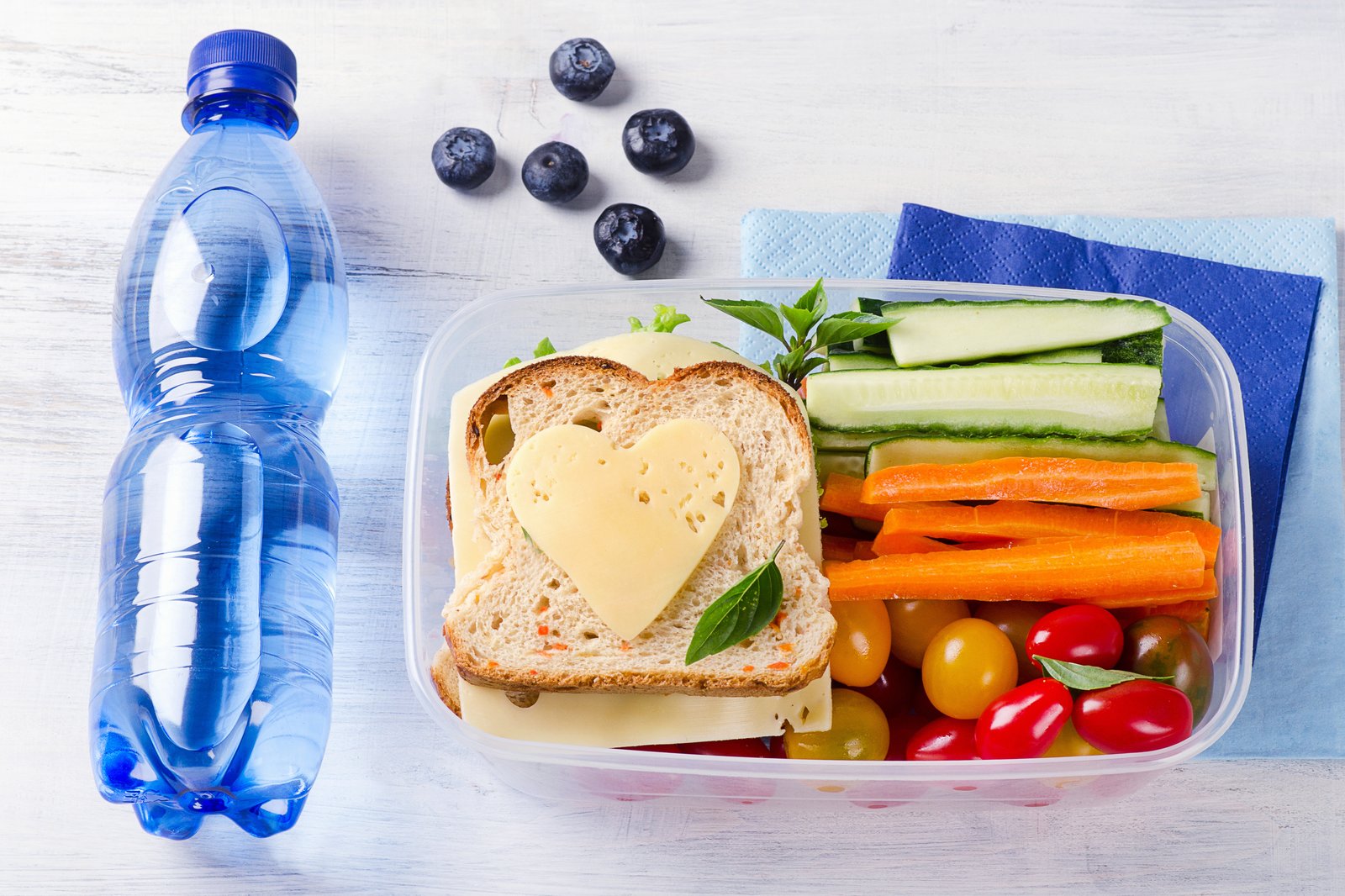 Healthy lunch box with cheese, fruit, and vegetables for kids